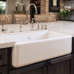 a large white kitchen sink sitting under a faucet next to a counter top