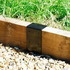 a piece of metal sitting on top of a wooden rail next to rocks and grass