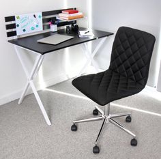 a black chair sitting in front of a desk with a computer on top of it