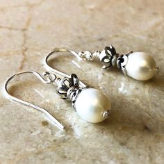 Looking for an effortless way to add a feminine touch to your outfit? Try these exquisite freshwater pearl earrings.  These double-stacked earrings feature a small white pearl placed atop a lustrous potato-shaped pearl encased in intricately woven silver filigree.  Not only do they add an extra layer of style to your look, but they also make for a perfect gift for several occasions. Pearls are symbols for the 3rd, 12th, and 30th wedding anniversaries, and pearl jewelry is a great gift for those Handmade Pearl Jewelry, White Pearl Earrings, Pearl Jewelry Design, White Pearl Earring, Stacked Earrings, Anniversary Jewelry, Handmade Jewelry Designs, June Birthstone, Sterling Silver Filigree