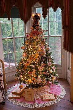 a decorated christmas tree sitting in front of a window