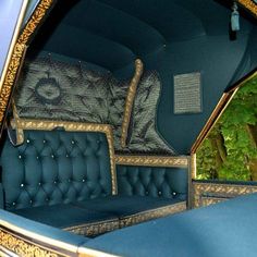 the interior of an old car with blue velvet upholstered seats and gold trim