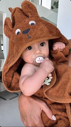 a baby wrapped in a brown bear towel