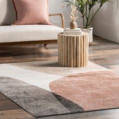 a living room with a couch, coffee table and potted plant on the floor