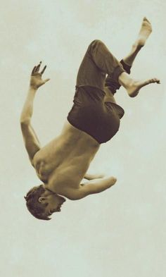 a man in the air doing a trick on a skateboard with his hands up