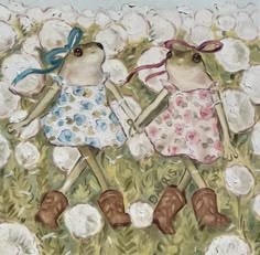 two little mice are walking in the grass with flowers on it's head and one has a blue ribbon around its neck