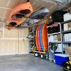 the inside of a garage with several kayaks and other things on shelves in it