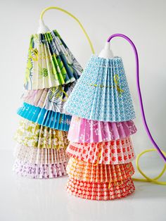 several different colored paper lamps on a white surface