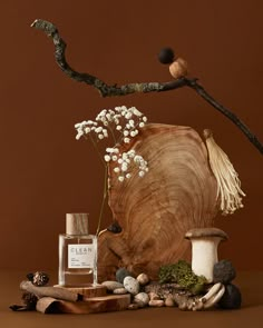 a wooden vase sitting on top of a table next to a tree branch and white flowers