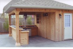 a small wooden shed with an outside kitchen