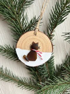 an ornament hanging from a pine tree with a brown and white decoration on it