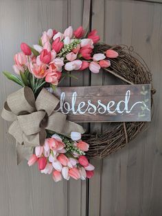 a wreath with flowers and a wooden sign that says, blessed