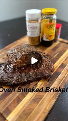 an open smoked brisket on a cutting board with mustard and seasonings in the background