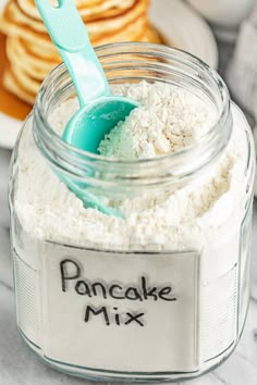 a jar filled with cake mix and a blue spoon sitting on top of the jar