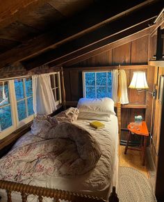 a bed sitting in the corner of a room next to two windows