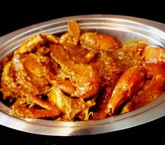 a metal bowl filled with cooked food on top of a table