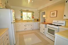 a kitchen with white appliances and yellow counter tops in the middle of the flooring