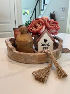 a wooden tray with flowers and a sign that says sweet home sitting on a table