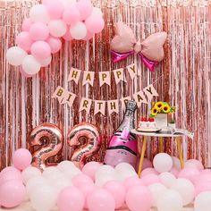 a birthday party with balloons, streamers and confetti on the table in front of it