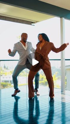 two people are dancing on a blue floor