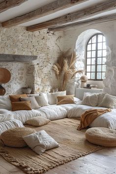 a living room filled with lots of white furniture and pillows on top of a rug