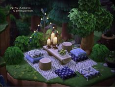 a table with candles and pillows on it in the middle of a forest, surrounded by trees