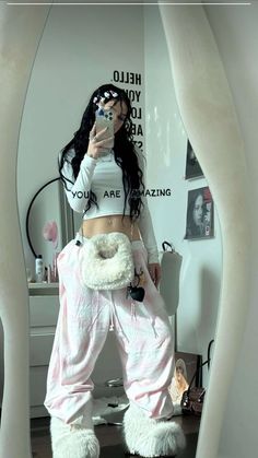 a woman taking a selfie in front of a mirror with her cell phone and stuffed animals