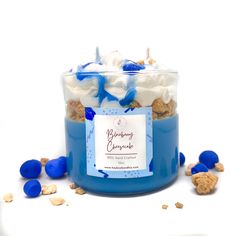 a blue glass jar filled with white and blue desserts on top of a table