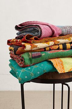 a stack of colorful blankets sitting on top of a table