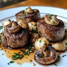 some very tasty looking meat and mushrooms on a white plate with garnishes