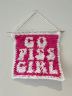 a pink and white crocheted sign hanging on a wall with the word go girl written across it