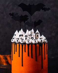 a halloween cake with white frosting and black decorations