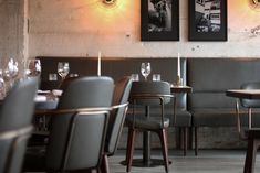 an empty restaurant with tables and chairs in front of the wall that has pictures on it