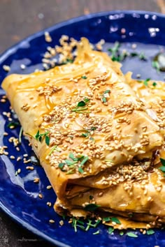 some food is on a blue plate with sesame seeds and seasoning sprinkles