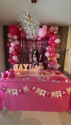 a pink birthday party with balloons and streamers