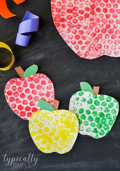 an apple craft made with construction paper and colored crayons on a blackboard