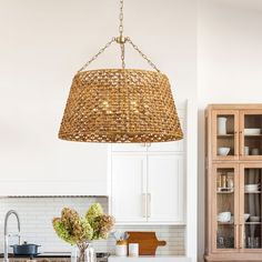 a light hanging over a kitchen counter top next to a wooden cabinet and white cabinets