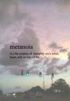 a traffic light with the words metanoia written on it in front of a cloudy sky