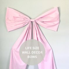 a pink bow with the words life size wall decor bows on it's side