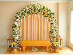 an orange and white floral decorated stage for a wedding ceremony with flowers on the wall