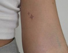 a small star tattoo on the left arm