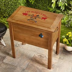 a small wooden box sitting on top of a patio next to a chair and potted plant