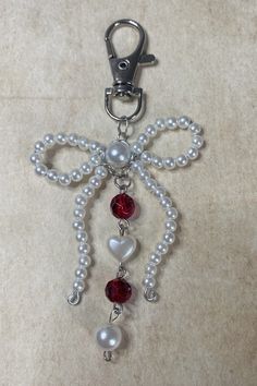 a keychain with pearls and beads attached to it's side on a carpeted surface