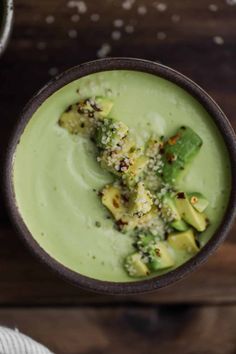 a green smoothie with avocado garnish and sprinkles