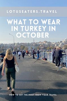 a woman walking across a bridge with the words, what to wear in turkey in october how to get the most from your travel