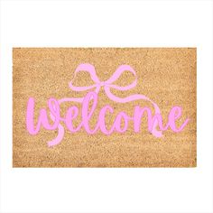 a welcome mat with the word welcome written in pink ink on it and a bow