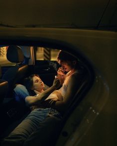 two people sitting in the back seat of a car