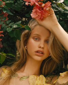 a woman with flowers in her hair posing for the camera