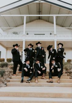 a group of men in suits and hats posing for a photo on the steps of a house