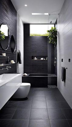 a modern bathroom with black tile and white fixtures